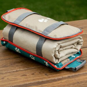 Folded portable dog blanket with paw print design, ready for travel.
